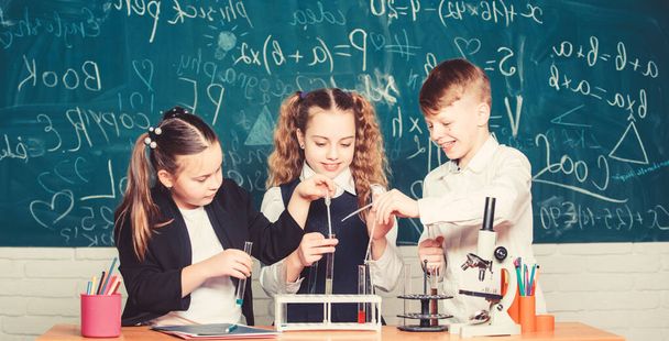 Group school pupils study chemistry in school. Boy and girls enjoy chemical experiment. Organic chemistry is study of compounds containing carbon. Basic chemical reactions. Fascinating chemistry - Zdjęcie, obraz