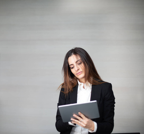 Businesswoman using a digital tablet in her office - Foto, Bild