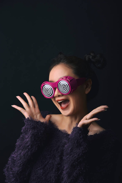 Mujer asiática sorprendida, producto de presentación de mano para publicidad, chica de la felicidad con gafas divertidas con más emocionante sensación de sorpresa
. - Foto, Imagen