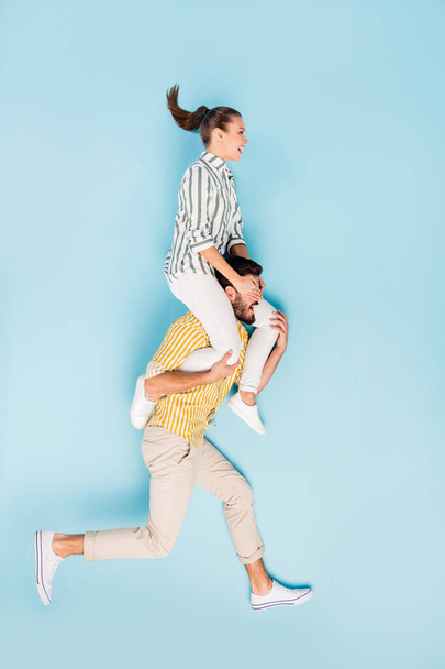 Vertical top view above high angle flat lay flatlay lie concept full length body size view of cheery couple running covering eyes isolated on bright vivid shine vibrant blue turquoise color background - Foto, immagini