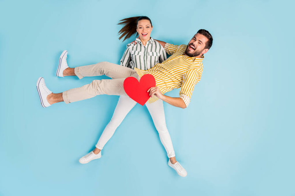 Visão superior acima de alto ângulo flat lay flatlay lie concept full length body size view of nice cheery girl carrying guy heart shape isolated on bright vivid shine vibrant blue turquesa color background
 - Foto, Imagem