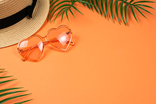 Pink sunglasses and a hat on orange background.  - Valokuva, kuva