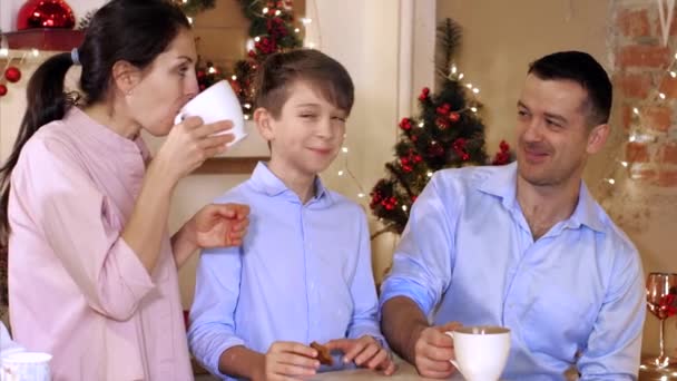 Family is drinking tea with homemade cookies at Christmas eve. - Imágenes, Vídeo