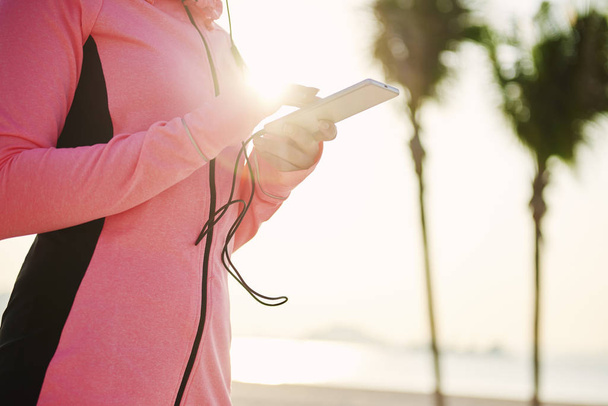 Close up of woman choosing the best song for running  - 写真・画像