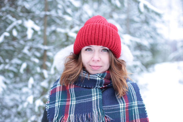 Красива дівчина з зеленими очима і імбирним волоссям в червоному капелюсі на прогулянці в зимовому сніжному лісі
 - Фото, зображення