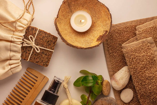 Lázeňský a wellness koncept, přírodní kávové mýdlo, olejový kosmetický sprej, peeling pískovcové kameny, ručník, přírodní dřevěný hřeben - Fotografie, Obrázek