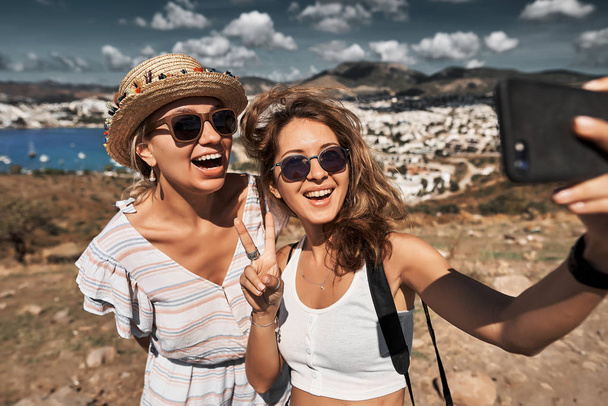 Happy friends travelers making selfie photo on a smatphone - Фото, зображення