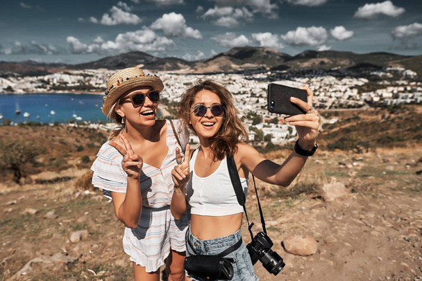 Happy friends travelers making selfie photo on a smatphone - Foto, Imagem