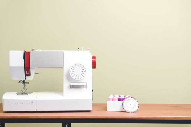 Máquina de coser con suministros en la mesa
 - Foto, imagen