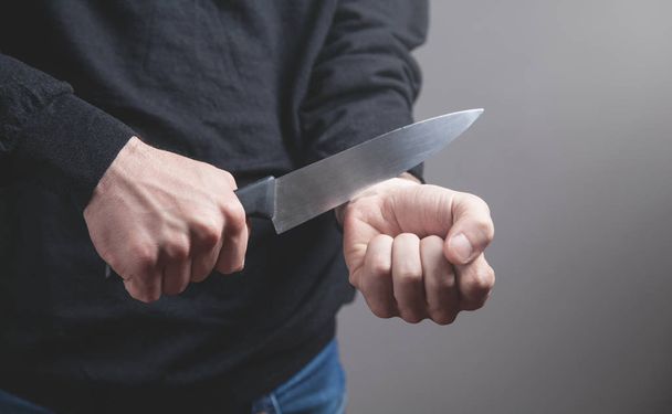 Άνθρωπος με μαχαίρι που κόβει φλέβες. Αυτοκτονία - Φωτογραφία, εικόνα
