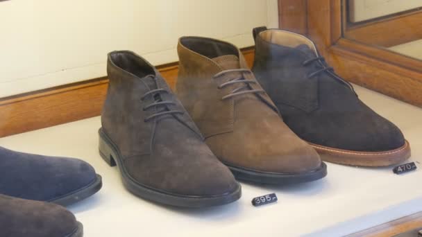 stilvolle Schuhe aus Wildleder am Schaufenster eines Schuhgeschäfts mit Preisschildern und Rabatten - Filmmaterial, Video