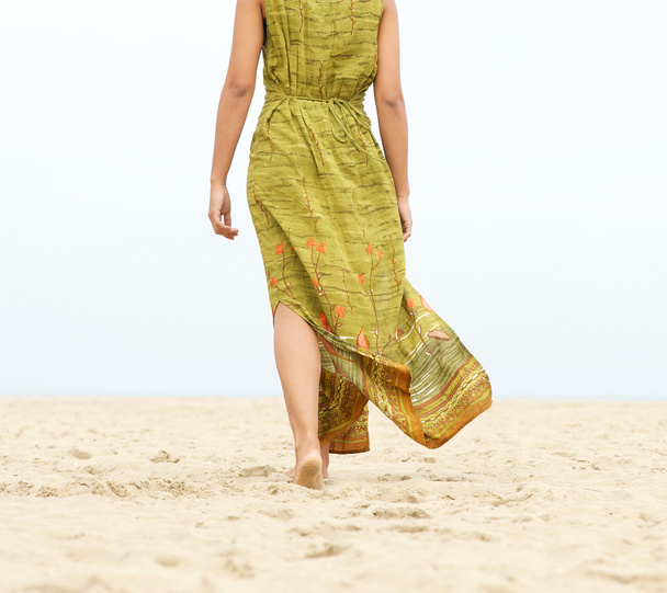 Портрет женщины, идущей босиком по пляжу
 - Фото, изображение