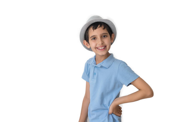 Щасливий хлопчик у капелюсі та футболці. Ізольовано на білому тлі. Шкільний хлопчик. Підліток
. - Фото, зображення