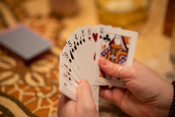 Selective focus of a hand of playing cards held by a person with a blurry background - Fotoğraf, Görsel