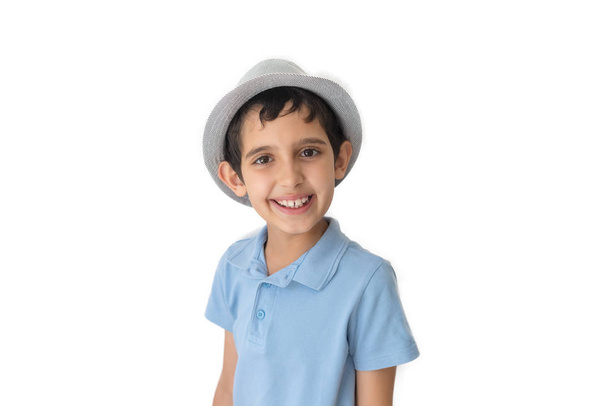 Ευτυχισμένο αγόρι με καπέλο και μπλουζάκι. Απομονωμένο σε λευκό φόντο. Σχολιαρόπαιδο. Έφηβος. - Φωτογραφία, εικόνα