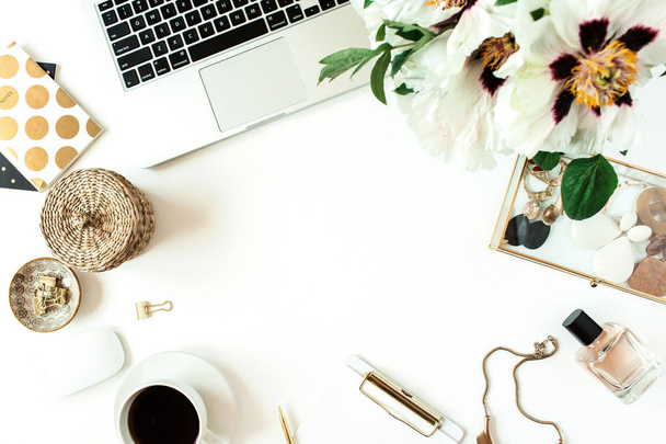Thuis bureau tafel werkruimte met laptop, bloemen en mode-accessoires op witte achtergrond. Flat lay, bovenaanzicht freelance werkconcept. Frame mockup met lege kopieerruimte. - Foto, afbeelding