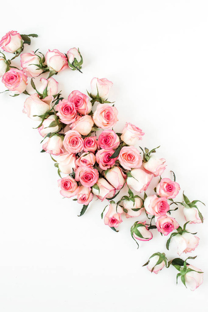 Bloemen compositie met roze roos bloemknoppen op witte achtergrond. Vlakke lay, bovenaanzicht. - Foto, afbeelding