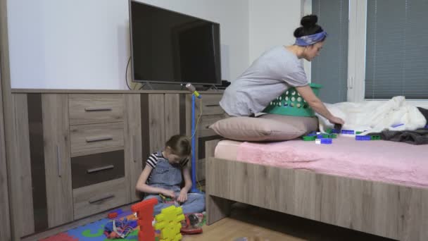 Mom tidy up Child scattered toys - Materiaali, video