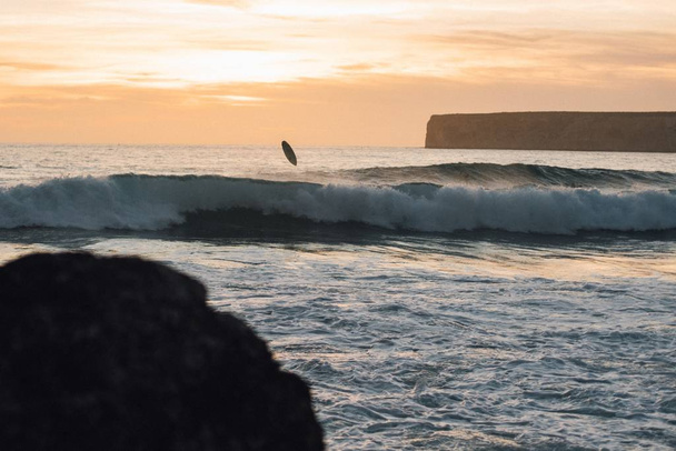 Surfing in the ocean in the Sagres municipality of Portugal during the sunset - Φωτογραφία, εικόνα
