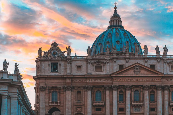 Famous St. Peter's Basilica in Vatican City and the sky with beautiful colors behind - Fotó, kép