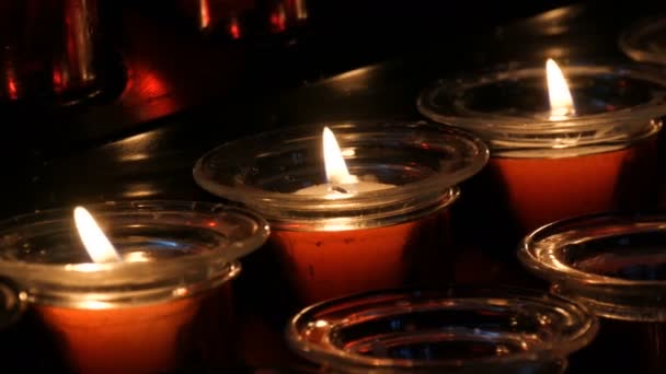 Égő temetés piros kerek gyertyák a templomban - Felvétel, videó