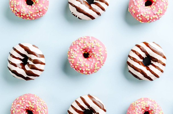 High angle closeup shot of delicious donuts on a light blue surface - perfect for a cool wallpaper - Foto, Imagem