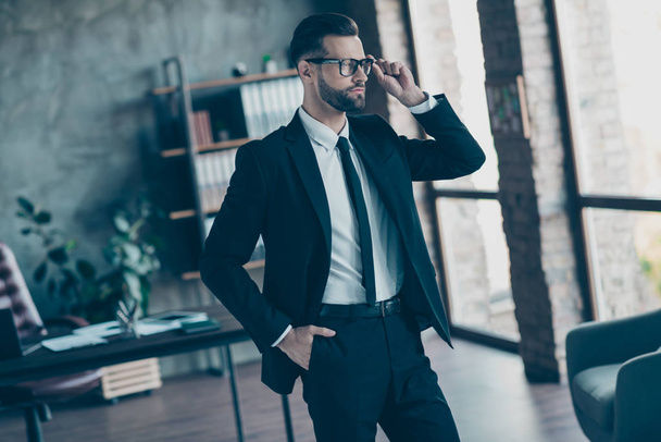 Photo of successful hot business guy self-confident person looking side deep thinking chief wear specs black blazer shirt tie pants belt suit costume standing office indoors - Фото, зображення