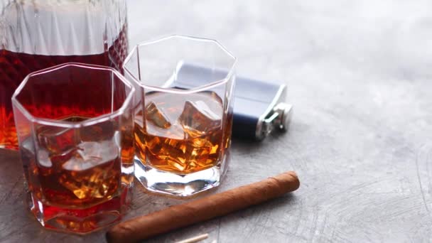 Dwie szklanki starej whisky z kubańskim cygarem i karafką - Materiał filmowy, wideo