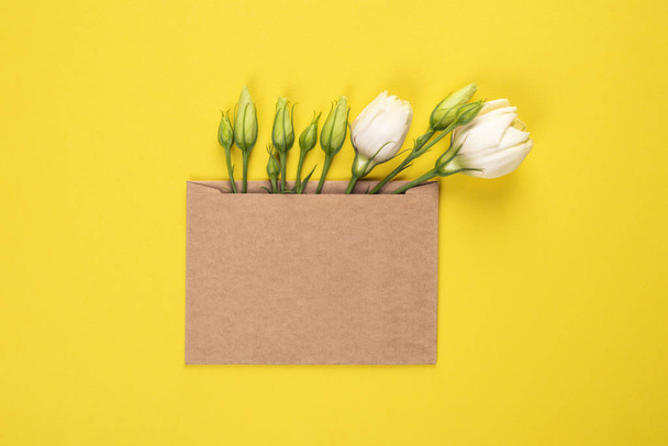 Eustoma flower arrangement with flowers and blank card, on yellow background - Photo, Image