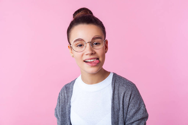 Portrait of adorable smart teenage girl with bun hairstyle in ca - Zdjęcie, obraz