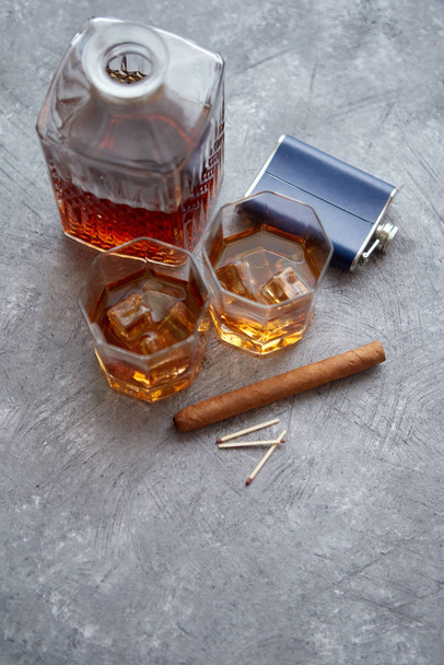 Kaksi lasillista vanhaa viskiä kuubalaisella sikarilla ja karahvilla
 - Valokuva, kuva