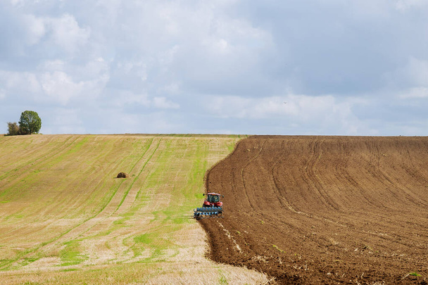Farmer on a tractor plows the land before sowing with a seedbed cultivator - Photo, Image