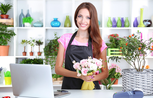 Beautiful girl florist with flowers in flowers shop - Zdjęcie, obraz