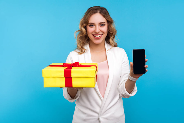 Gift, bonuses in mobile tariff. Portrait of cheerful woman showi - Zdjęcie, obraz