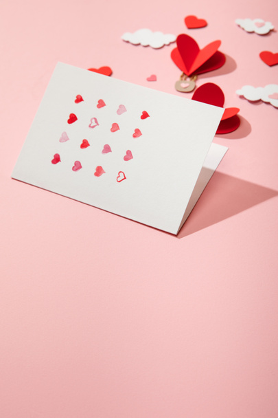 selective focus of greeting card with hearts near paper heart shaped air balloons in clouds on pink - Fotoğraf, Görsel