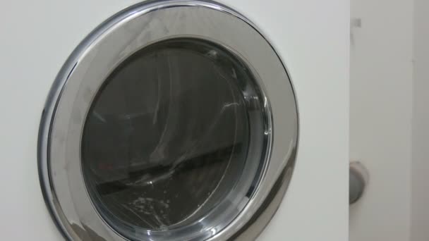 Roupas pretas e brancas. Lavandaria é lavada em uma máquina de lavar roupa branca na lavanderia
. - Filmagem, Vídeo