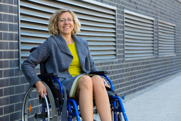 young adult woman on wheelchair on the street - Foto, imagen