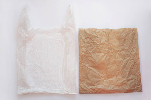 Pusta plastikowa torba vs brązowy opakowanie z recyklingu papieru. Powiedz "nie" plastikowi. Zmniejszenie, ponowne wykorzystanie i recykling koncepcji.Ekologiczna torba. - Zdjęcie, obraz