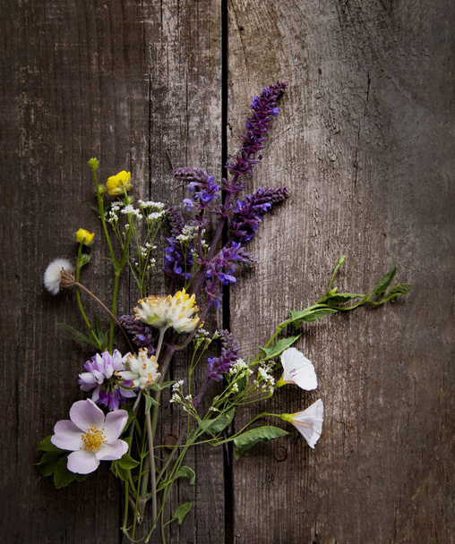 Wilde bloemen op oude grunge houten achtergrond (lupine paardebloemen - Foto, afbeelding