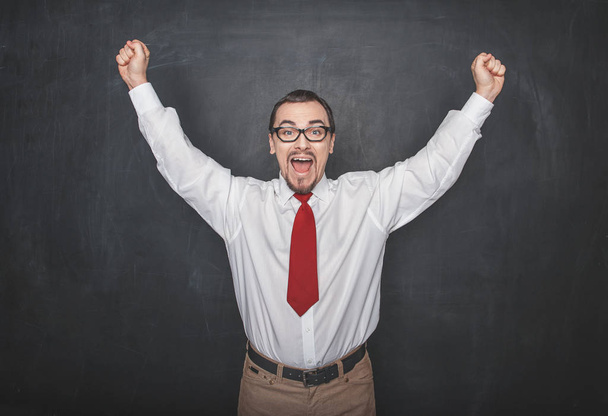 Successful happy man with raising arms on chalkboard background - Photo, Image