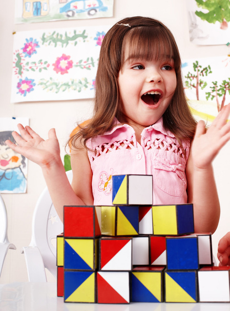 Kind mit Holzblock und Konstruktion im Spielzimmer. - Foto, Bild