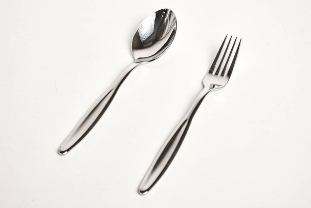 close-up view of shiny silver fork and spoon on white background - Fotoğraf, Görsel