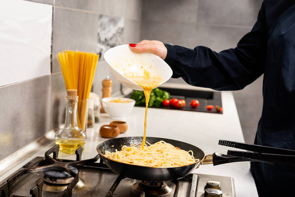 обрезанный снимок человека, готовящего вкусную итальянскую пасту на кухне
 - Фото, изображение