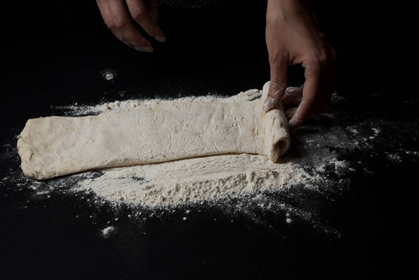 close-up partial view of woman preparing fresh homemade pastry on black background  - Foto, Imagem