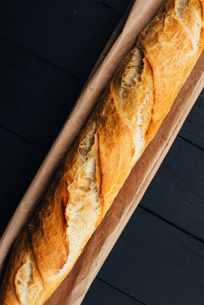 top view of delicious fresh bread on wooden background - Foto, imagen