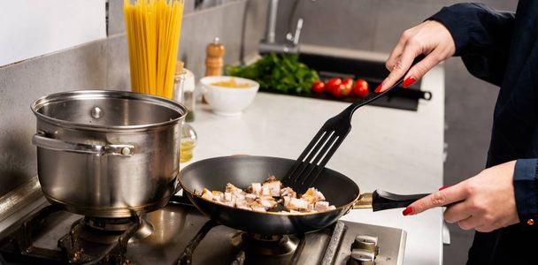 partial view of person cooking ingredients for italian pasta in kitchen - Foto, Bild