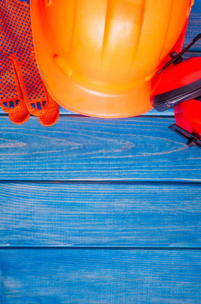 Πορτοκαλί σκληρό καπέλο και εργαλείο σε ξύλινα vintage μπλε σανίδες - Φωτογραφία, εικόνα