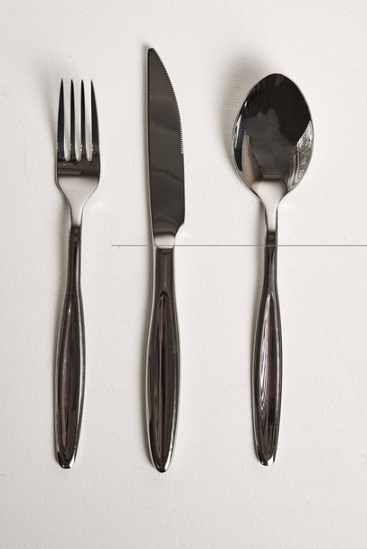top view of spoon, fork and knife on white background - Foto, imagen