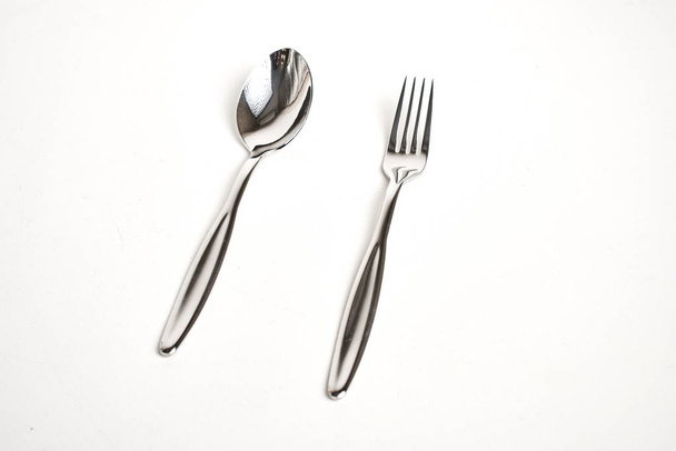 close-up view of shiny spoon and fork on white background  - Fotoğraf, Görsel