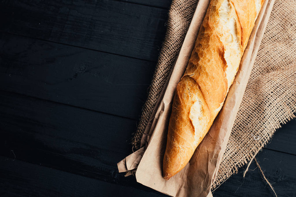 top view of delicious fresh homemade baguette on wooden background  - Foto, Imagem